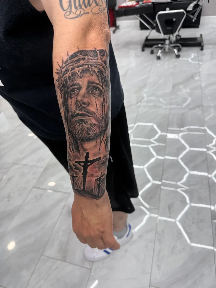 Black and Grey Jesus Crucifix Forearm Tattoo